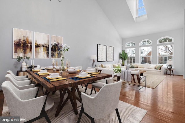 dining room featuring wood-type flooring and high vaulted ceiling