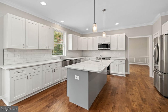 kitchen with stainless steel appliances, a center island with sink, white cabinets, and light stone counters