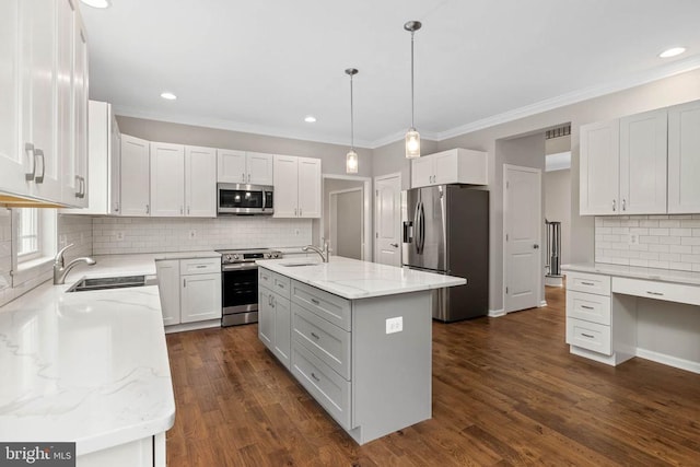 kitchen featuring pendant lighting, an island with sink, white cabinetry, appliances with stainless steel finishes, and sink