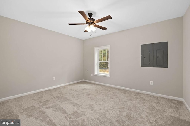 spare room with electric panel, ceiling fan, and light carpet