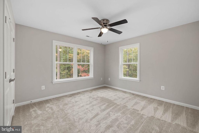 empty room featuring ceiling fan and light colored carpet