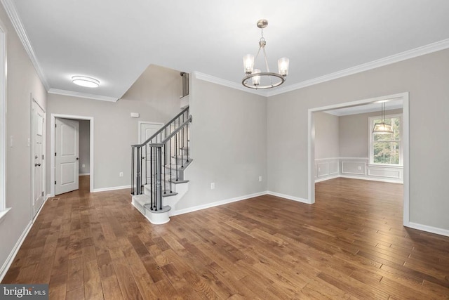 entrance foyer featuring ornamental molding, an inviting chandelier, and dark hardwood / wood-style floors