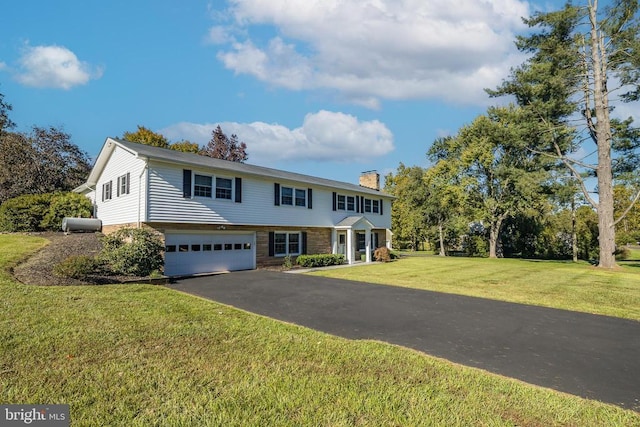 view of front of home with a front yard and a garage