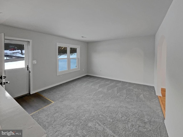 interior space with dark carpet and a healthy amount of sunlight