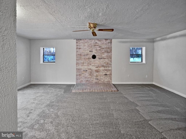 unfurnished living room featuring dark carpet, a textured ceiling, and ceiling fan