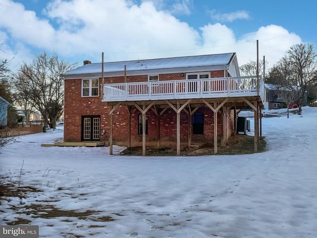 snow covered house featuring a wooden deck