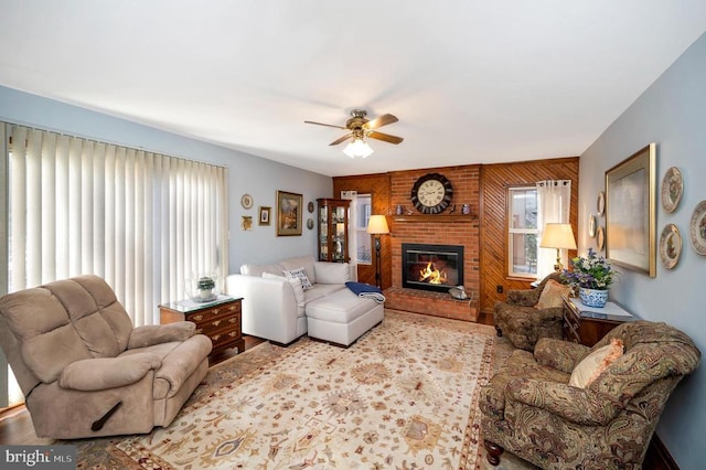 living room featuring a brick fireplace, ceiling fan, and wooden walls