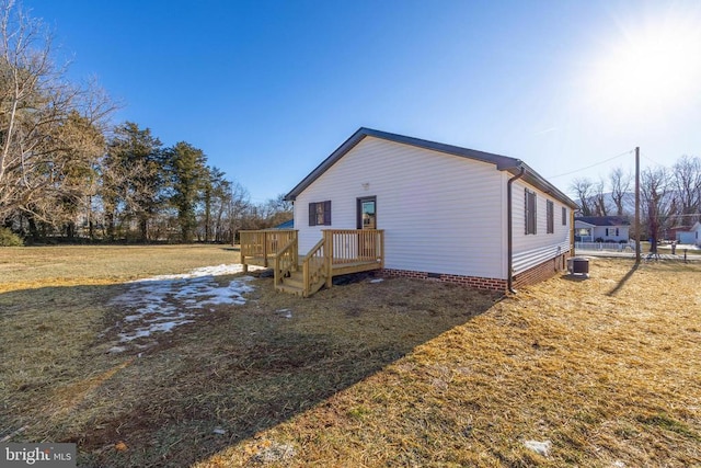 view of side of property featuring central AC unit, a yard, and a deck