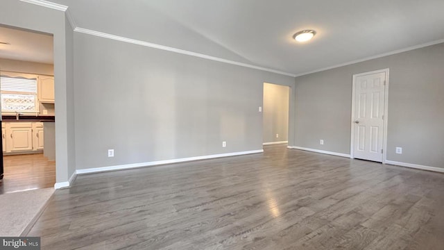 unfurnished room featuring sink, hardwood / wood-style floors, and ornamental molding