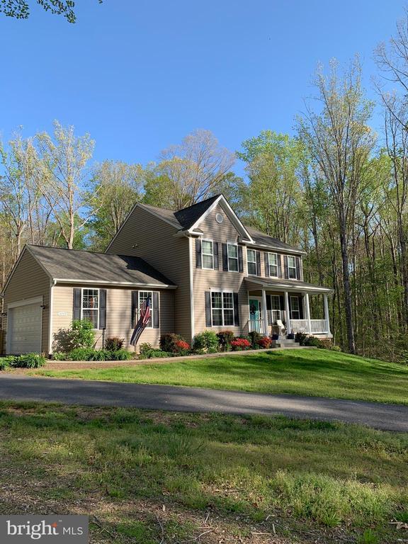 view of front of house featuring a front yard, covered porch, and a garage