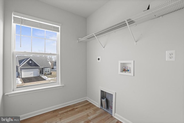 laundry room featuring hookup for a washing machine, light hardwood / wood-style floors, and hookup for an electric dryer