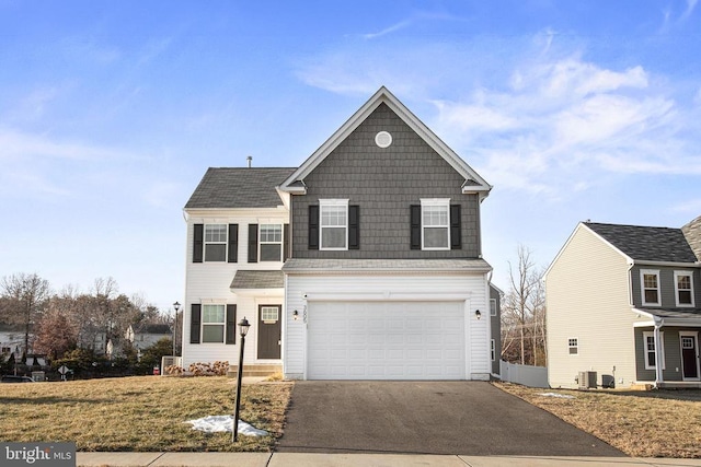 view of property with a garage, a front yard, and central AC unit