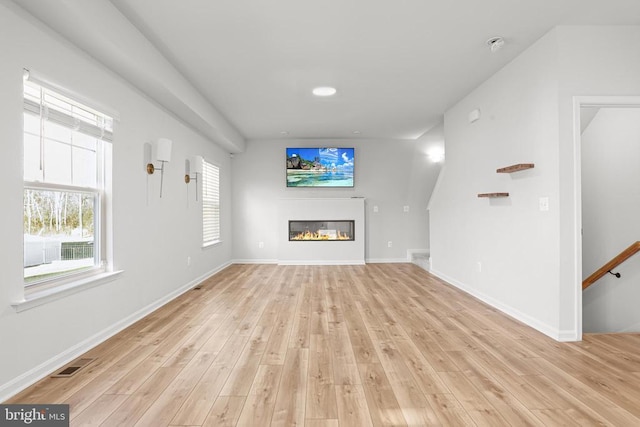 unfurnished living room with plenty of natural light and light hardwood / wood-style flooring