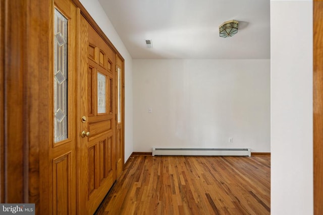 foyer entrance with baseboard heating and hardwood / wood-style flooring