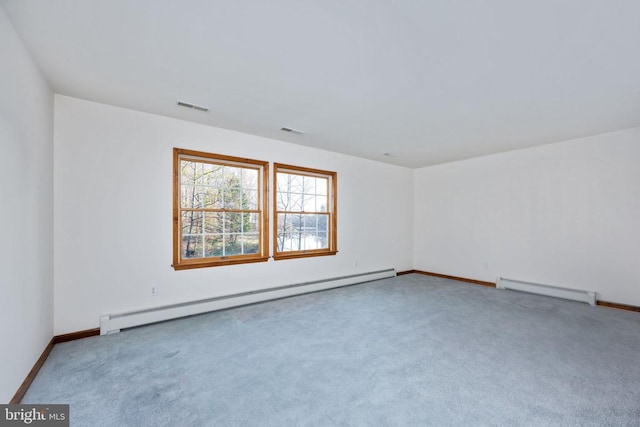 carpeted empty room with a baseboard heating unit