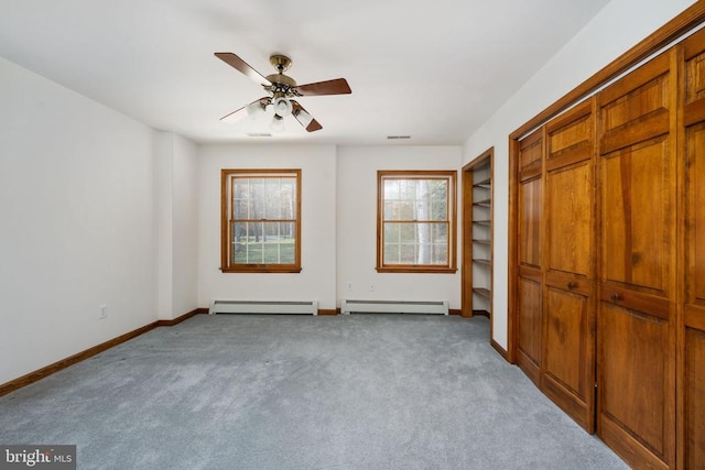 unfurnished bedroom with ceiling fan, light colored carpet, and a baseboard heating unit