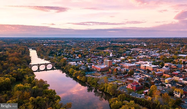 aerial view at dusk featuring a water view