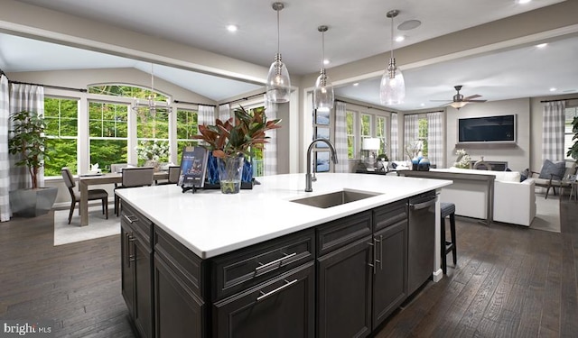 kitchen with an island with sink, sink, dark hardwood / wood-style floors, vaulted ceiling, and ceiling fan