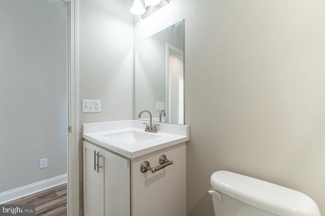 bathroom featuring toilet, hardwood / wood-style floors, and vanity