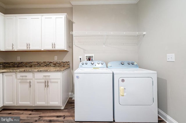 washroom with cabinets, dark hardwood / wood-style flooring, crown molding, and washer and clothes dryer