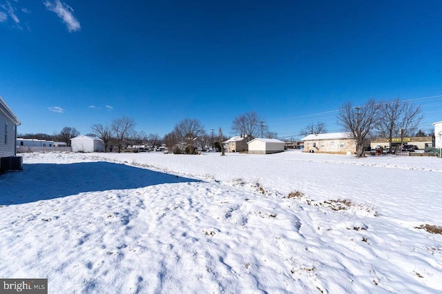 yard covered in snow featuring central AC unit