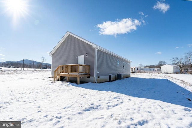 snow covered property with central AC unit and a mountain view