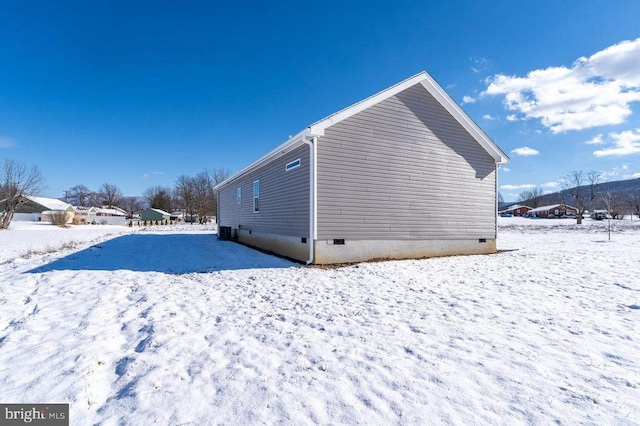 view of snow covered back of property