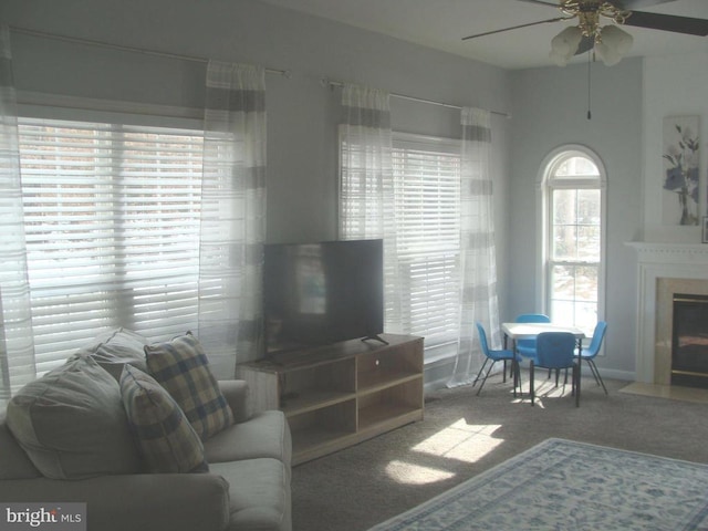 carpeted living room with ceiling fan