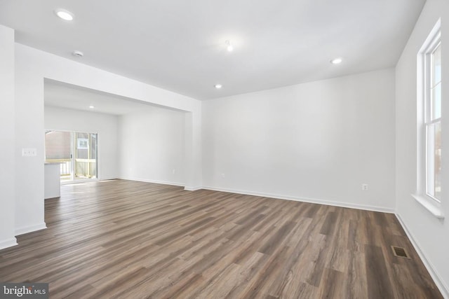 spare room with plenty of natural light and dark hardwood / wood-style flooring