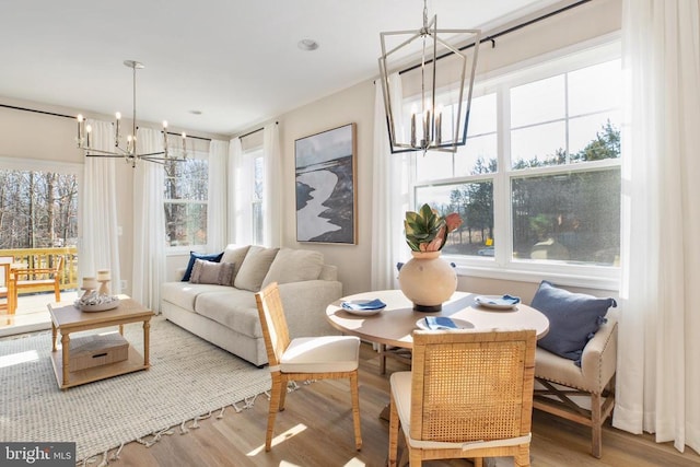 dining space with wood-type flooring and a notable chandelier