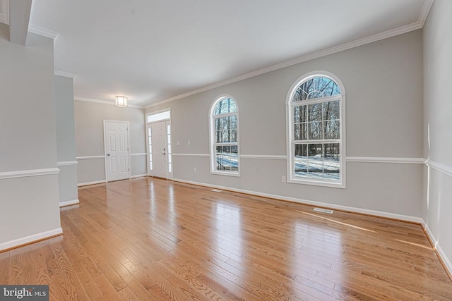 spare room featuring ornamental molding and light hardwood / wood-style floors