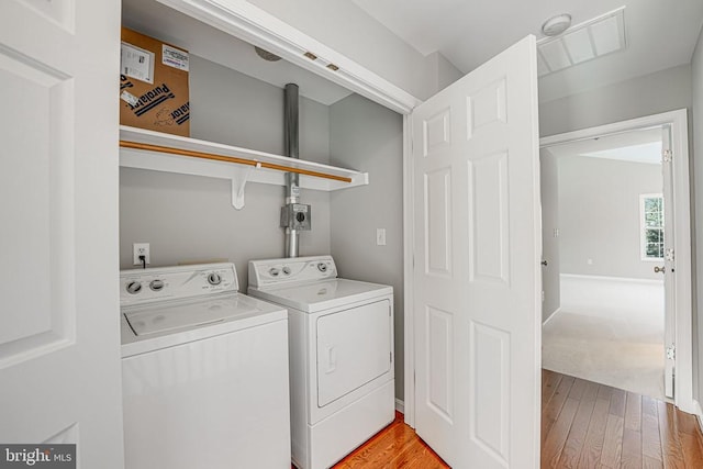 washroom with wood-type flooring and washer and dryer