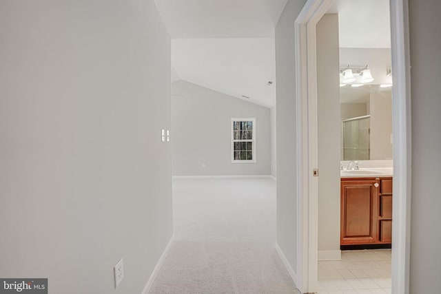 hall featuring sink, vaulted ceiling, and light carpet