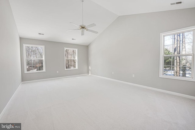 carpeted spare room with ceiling fan and vaulted ceiling