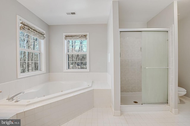 bathroom featuring tile patterned flooring, toilet, and separate shower and tub