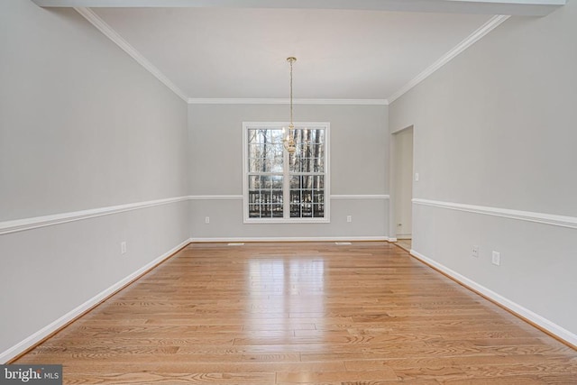 unfurnished dining area featuring ornamental molding, a notable chandelier, and light hardwood / wood-style flooring