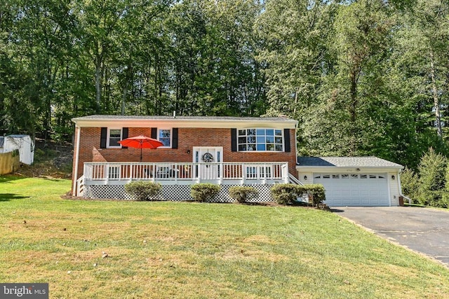 raised ranch featuring a garage, a wooden deck, and a front lawn