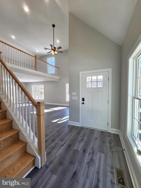 entrance foyer featuring high vaulted ceiling, dark hardwood / wood-style floors, and ceiling fan