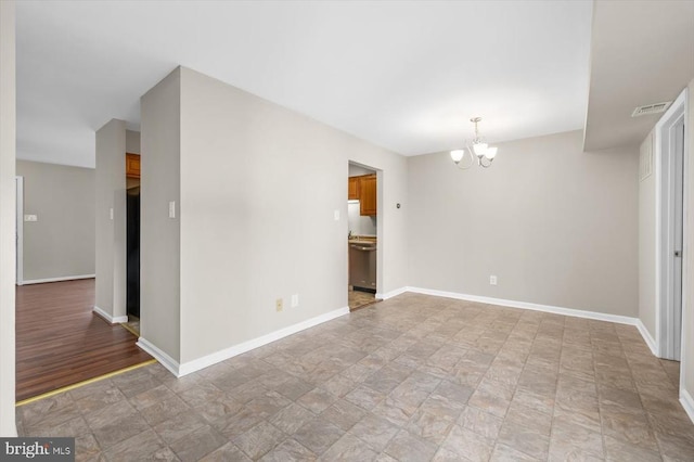 unfurnished room with a chandelier