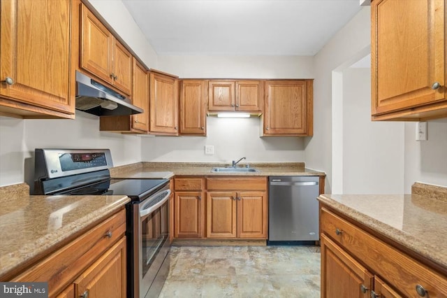 kitchen featuring light stone countertops, appliances with stainless steel finishes, and sink