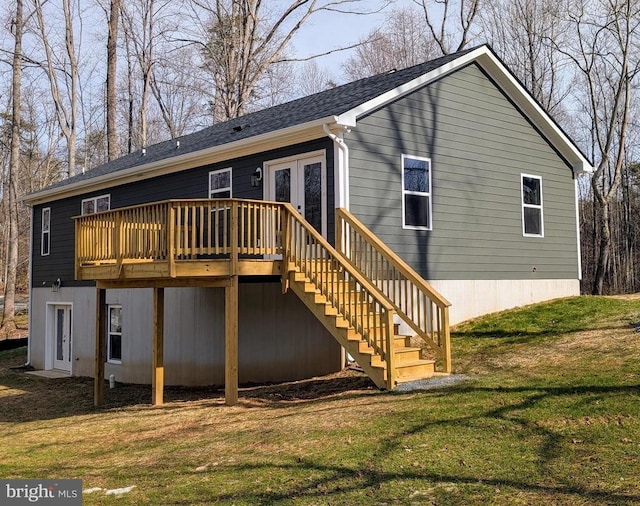 rear view of house with a wooden deck, a yard, and french doors