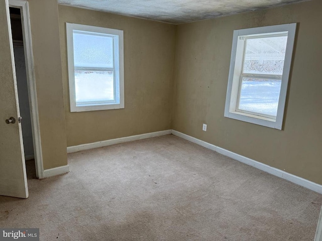 carpeted empty room with plenty of natural light and a textured ceiling