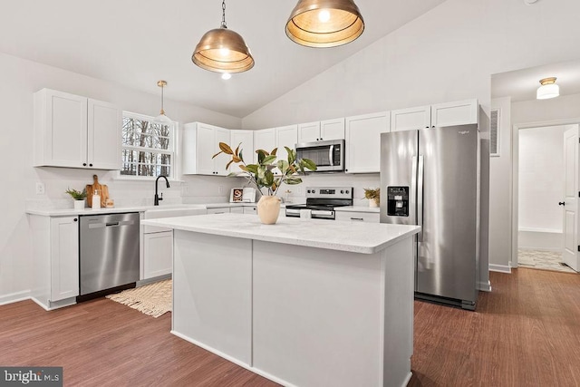 kitchen with stainless steel appliances, sink, hanging light fixtures, and white cabinets