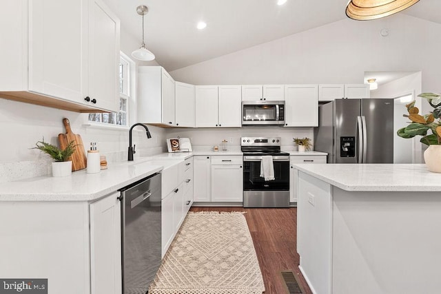 kitchen featuring sink, white cabinetry, pendant lighting, stainless steel appliances, and light stone countertops