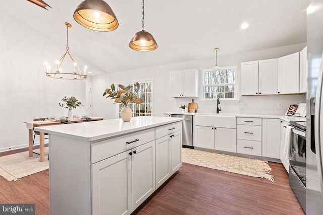 kitchen with pendant lighting, white cabinetry, appliances with stainless steel finishes, and sink