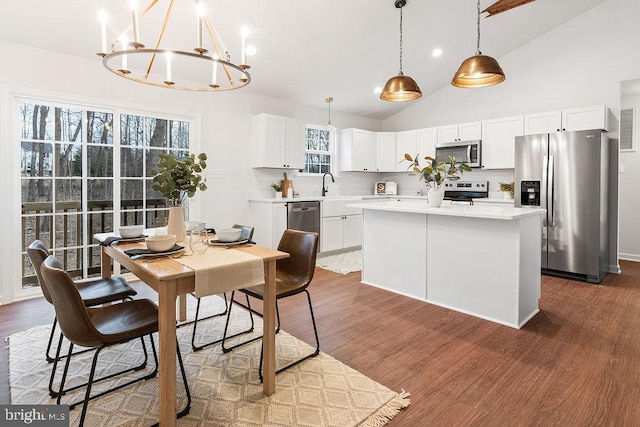 dining room with dark wood-type flooring and high vaulted ceiling