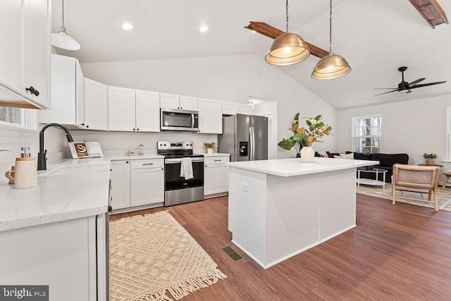 kitchen with dark hardwood / wood-style floors, white cabinetry, sink, hanging light fixtures, and stainless steel appliances