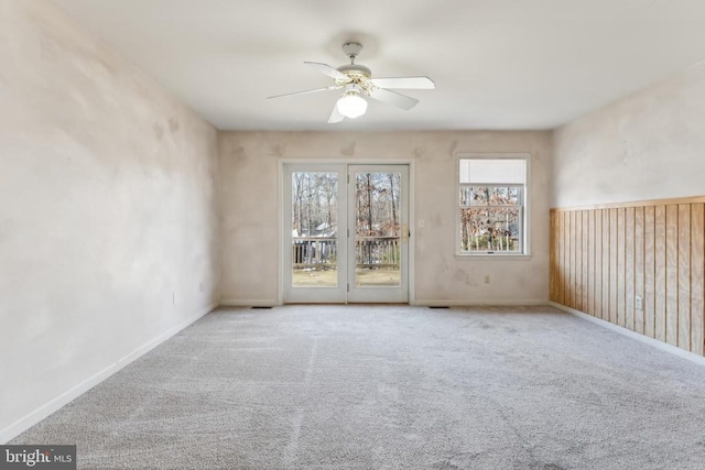 carpeted spare room featuring ceiling fan