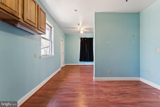 empty room with dark hardwood / wood-style flooring and ceiling fan