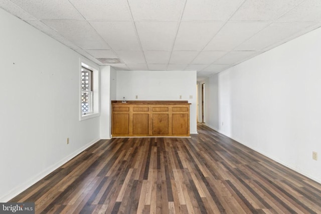 interior space with sink, dark wood-type flooring, and a paneled ceiling